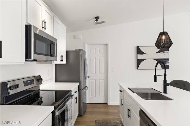 kitchen featuring light countertops, appliances with stainless steel finishes, a sink, and white cabinets