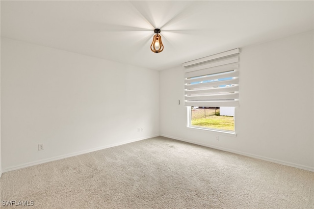 carpeted empty room with baseboards