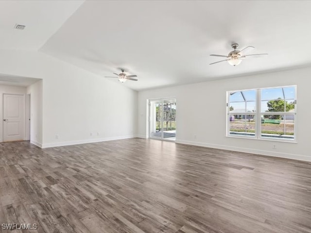 unfurnished living room featuring a wealth of natural light, ceiling fan, and wood-type flooring