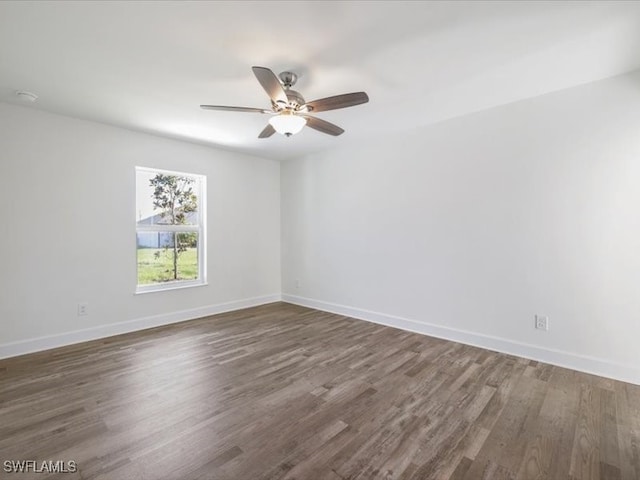 empty room with ceiling fan and dark hardwood / wood-style flooring