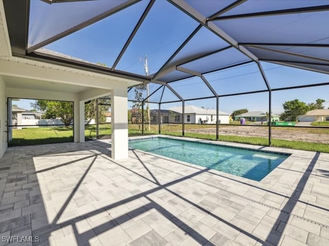 view of swimming pool featuring a lanai, a patio area, and a lawn