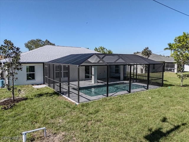 back of property featuring glass enclosure, a patio area, and a lawn