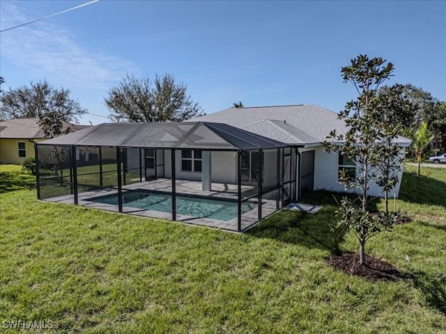 back of property with a yard, glass enclosure, and a patio area