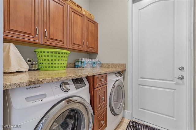 clothes washing area with separate washer and dryer, light tile patterned floors, and cabinets