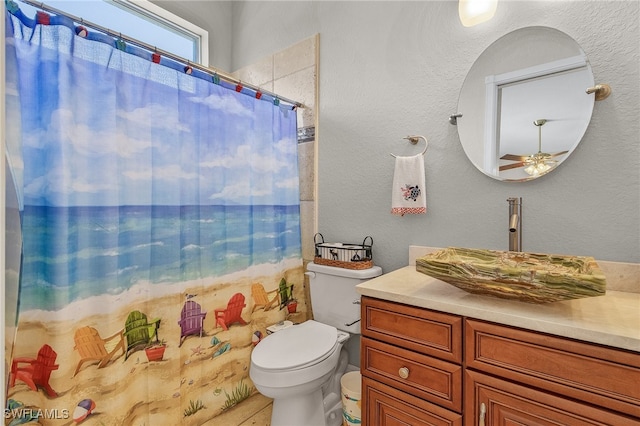 bathroom featuring ceiling fan, vanity, a shower with shower curtain, and toilet