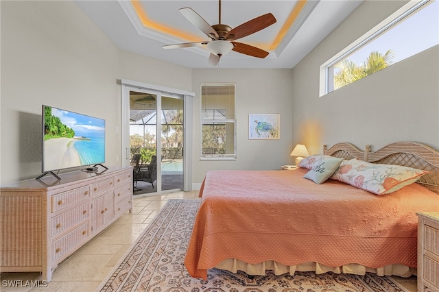 bedroom featuring ceiling fan, crown molding, access to outside, and a tray ceiling