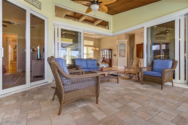 sunroom featuring beam ceiling, ceiling fan with notable chandelier, and wood ceiling