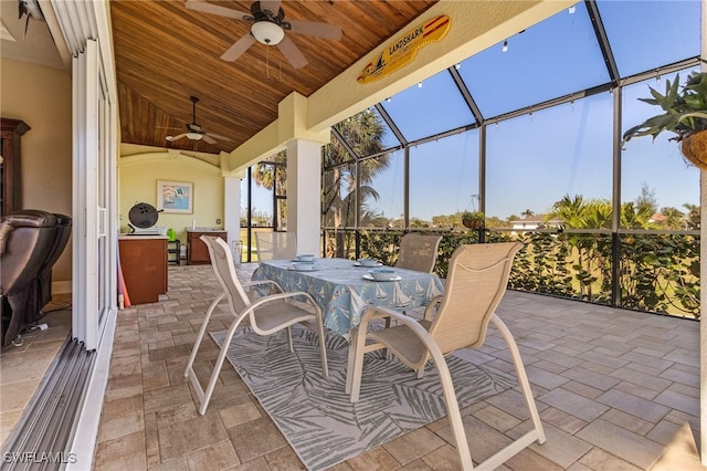 view of patio featuring ceiling fan and glass enclosure