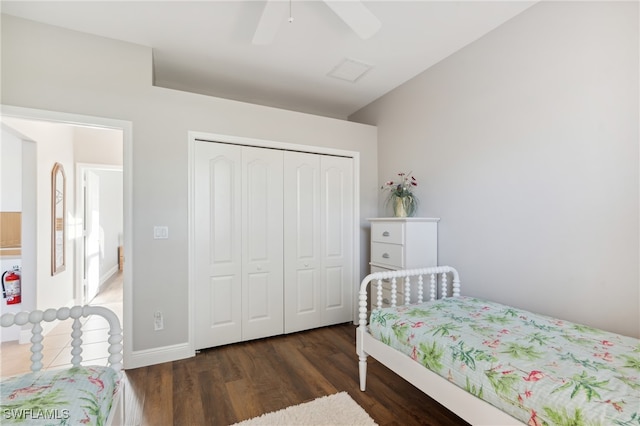 bedroom with ceiling fan, a closet, and dark wood-type flooring