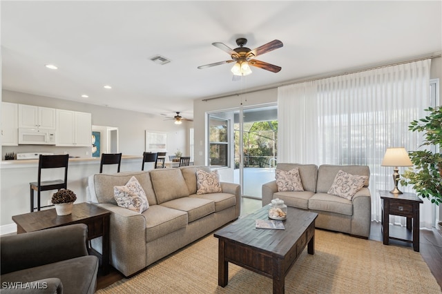 living room with ceiling fan and light hardwood / wood-style floors