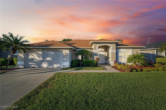 view of front of home with a lawn and a garage