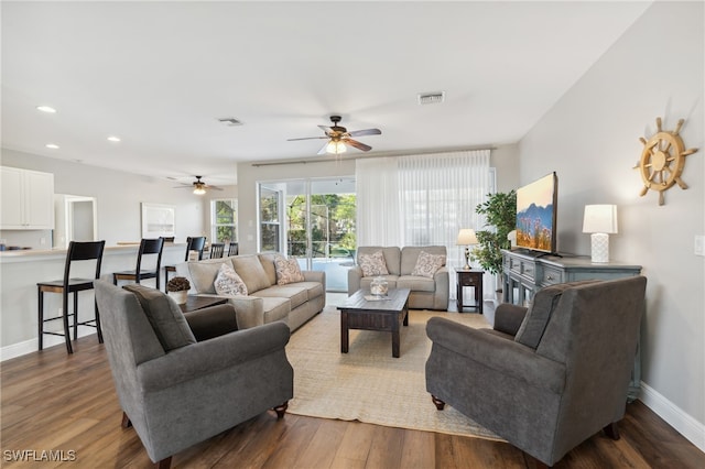 living room featuring ceiling fan and dark hardwood / wood-style flooring