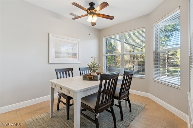 tiled dining space featuring ceiling fan and a healthy amount of sunlight