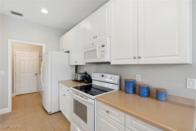 kitchen featuring white cabinetry, light tile patterned floors, and white appliances