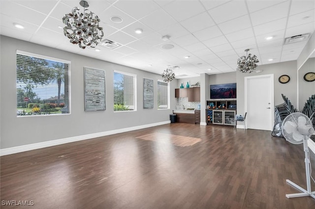 exercise area featuring a paneled ceiling and dark hardwood / wood-style flooring