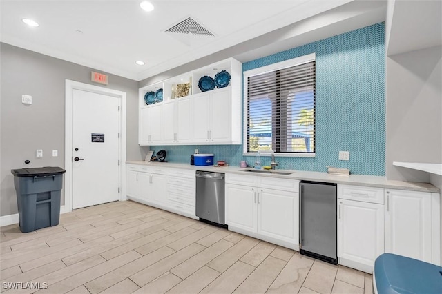 kitchen with sink, decorative backsplash, appliances with stainless steel finishes, light hardwood / wood-style floors, and white cabinetry