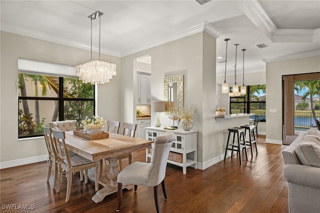 dining area featuring crown molding, dark wood-type flooring, and an inviting chandelier