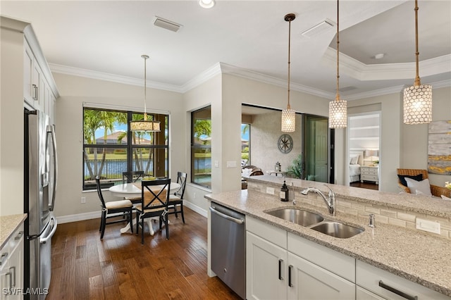 kitchen featuring stainless steel appliances, white cabinetry, hanging light fixtures, and sink