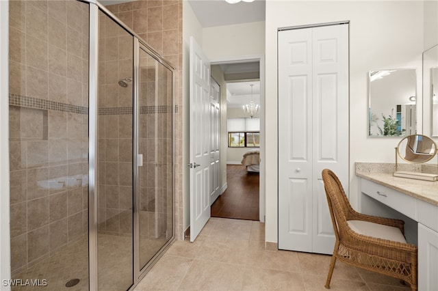 bathroom featuring hardwood / wood-style floors, vanity, walk in shower, and an inviting chandelier