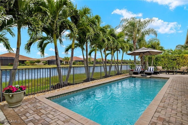 view of pool with a water view and a patio