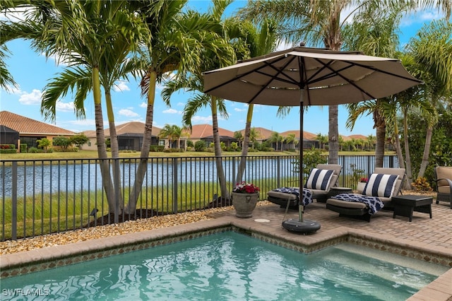 view of swimming pool featuring a patio and a water view