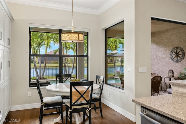 dining room with crown molding, a water view, and dark wood-type flooring