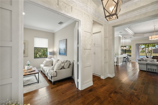 interior space with dark hardwood / wood-style flooring, ornamental molding, and a chandelier