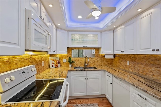 kitchen with white cabinetry, a raised ceiling, white appliances, and sink