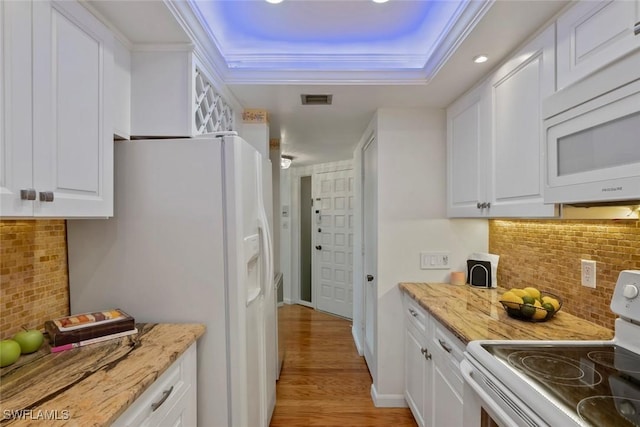 kitchen featuring tasteful backsplash, white appliances, visible vents, white cabinets, and a raised ceiling
