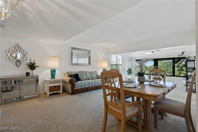carpeted dining room featuring a wealth of natural light, an inviting chandelier, and a textured ceiling