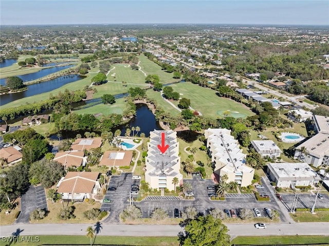 drone / aerial view featuring view of golf course, a water view, and a residential view