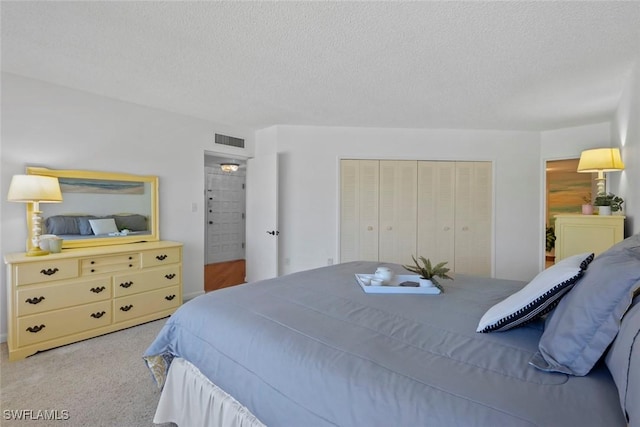 bedroom featuring a textured ceiling, carpet, a closet, and visible vents