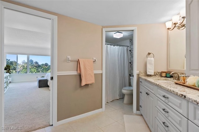 bathroom featuring toilet, baseboards, tile patterned floors, vanity, and a chandelier