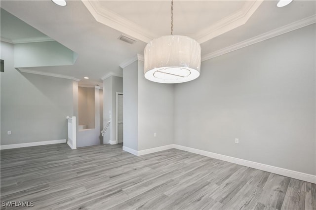 spare room with an inviting chandelier, crown molding, and light hardwood / wood-style flooring