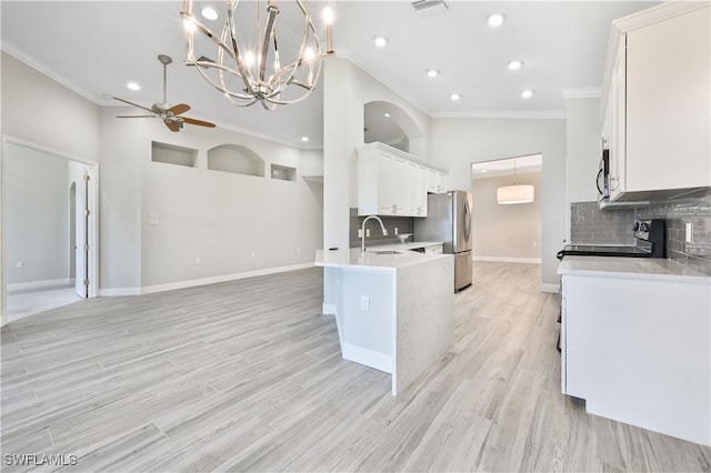 kitchen with white cabinets, appliances with stainless steel finishes, light wood-type flooring, and crown molding