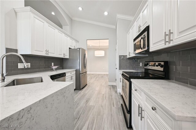 kitchen with light stone countertops, appliances with stainless steel finishes, sink, light hardwood / wood-style flooring, and white cabinetry