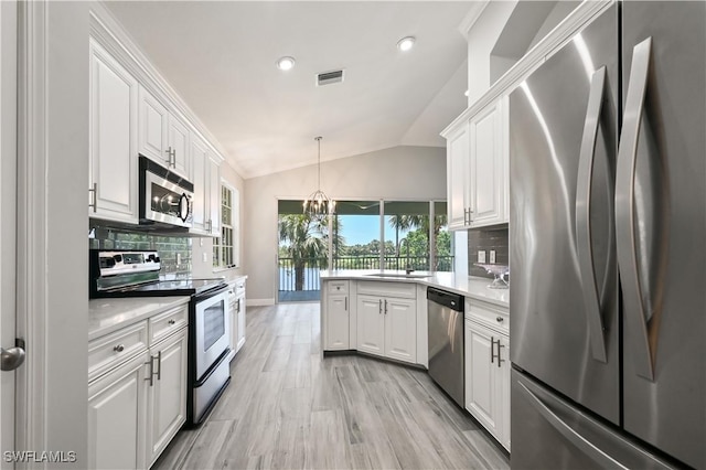 kitchen featuring appliances with stainless steel finishes, tasteful backsplash, sink, white cabinetry, and lofted ceiling