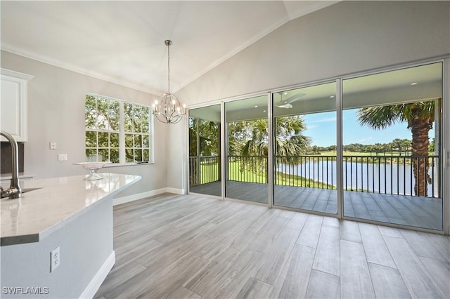 doorway with light hardwood / wood-style floors, a water view, lofted ceiling, and a wealth of natural light