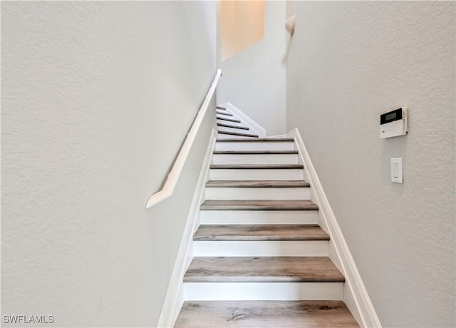 staircase with hardwood / wood-style floors