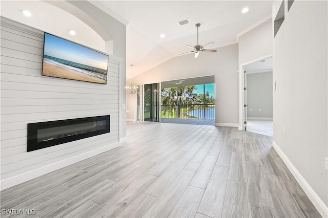 unfurnished living room with lofted ceiling, crown molding, ceiling fan, light wood-type flooring, and a large fireplace