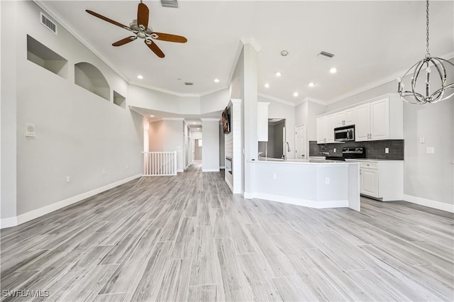 kitchen featuring white cabinets, crown molding, light wood-type flooring, and stainless steel appliances