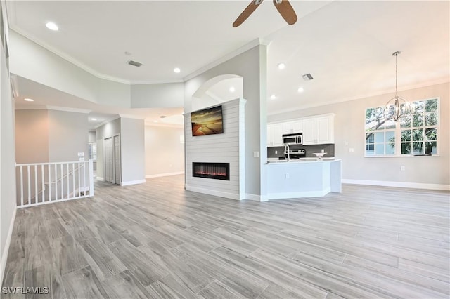 unfurnished living room featuring a fireplace, crown molding, and light hardwood / wood-style flooring