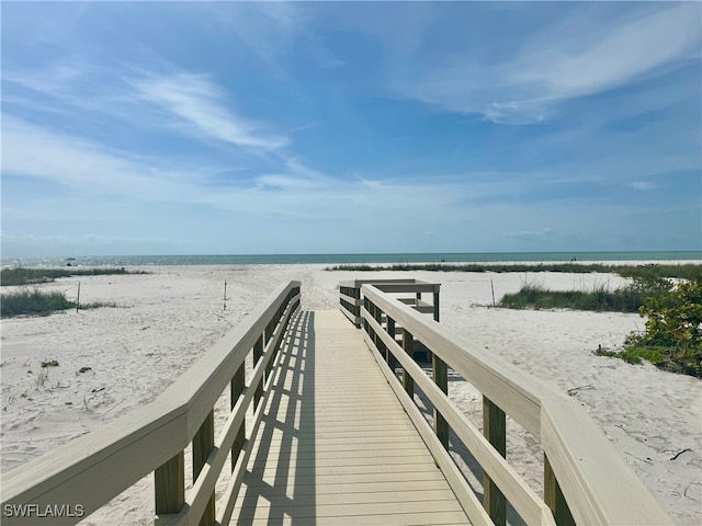 view of dock featuring a view of the beach and a water view