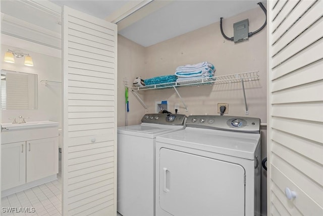 washroom with sink, washer and dryer, and light tile patterned floors