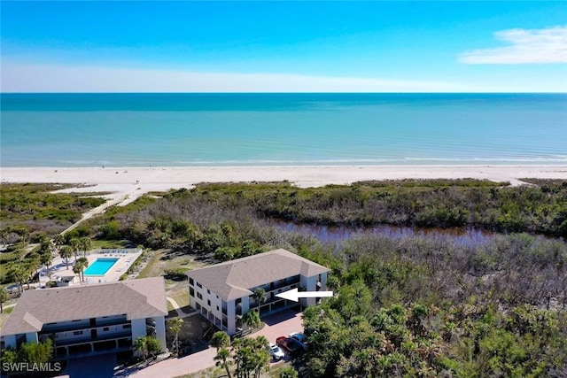 bird's eye view featuring a water view and a beach view