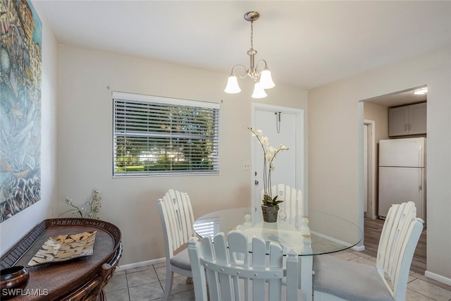 tiled dining room featuring a chandelier