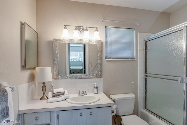 full bathroom with vanity, toilet, combined bath / shower with glass door, and tasteful backsplash