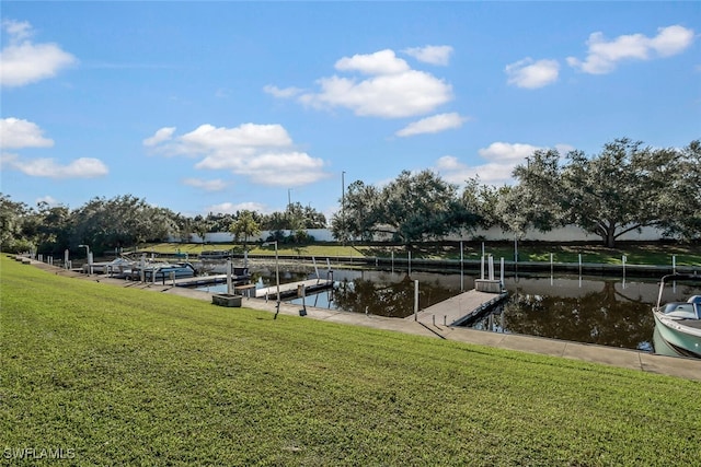 dock area with a lawn and a water view