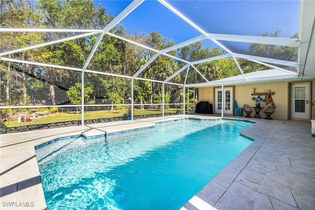 view of swimming pool featuring a lanai, a patio area, and french doors