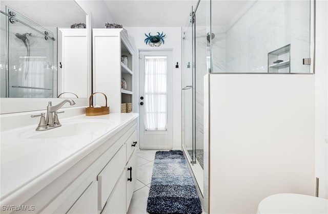 bathroom with tile patterned flooring, vanity, walk in shower, and a textured ceiling